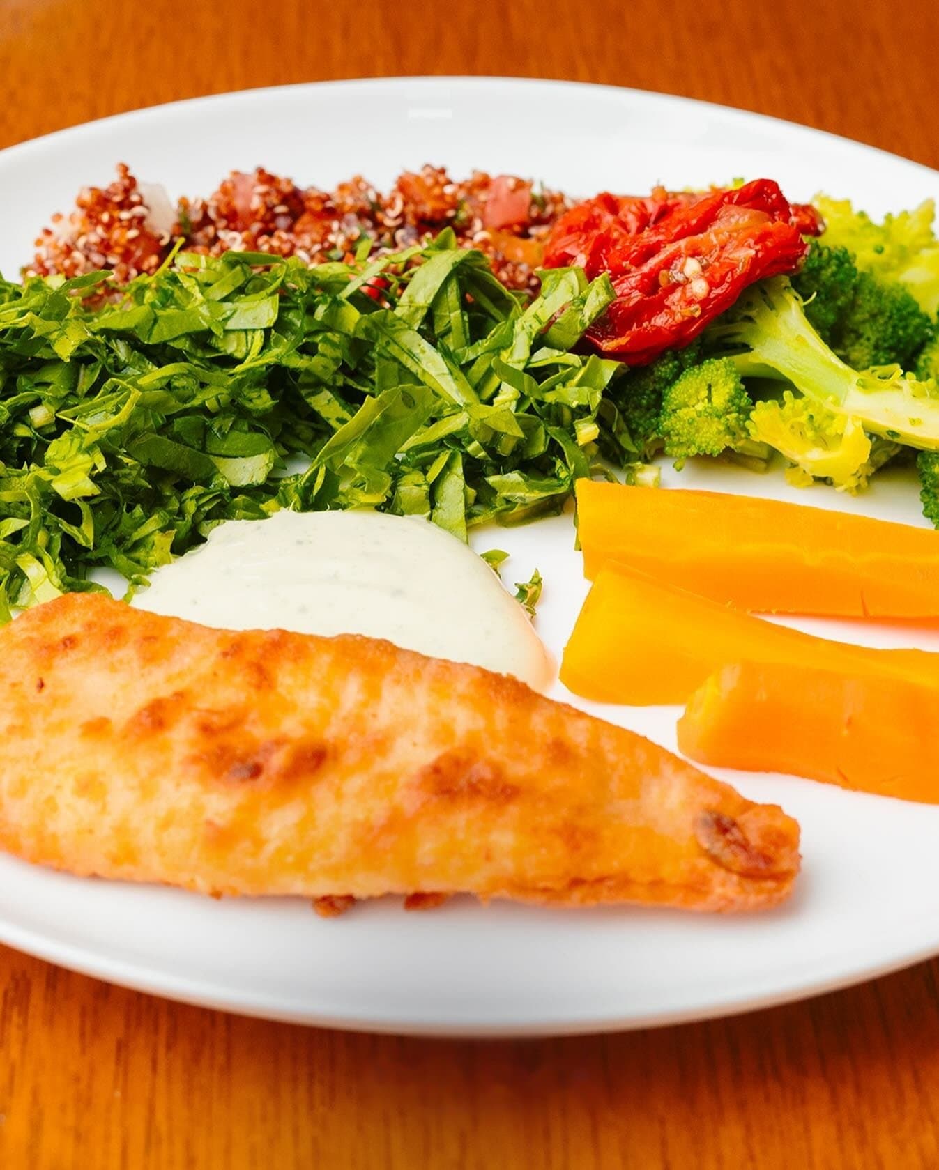 Prato com filé, salada, legumes e quinoa