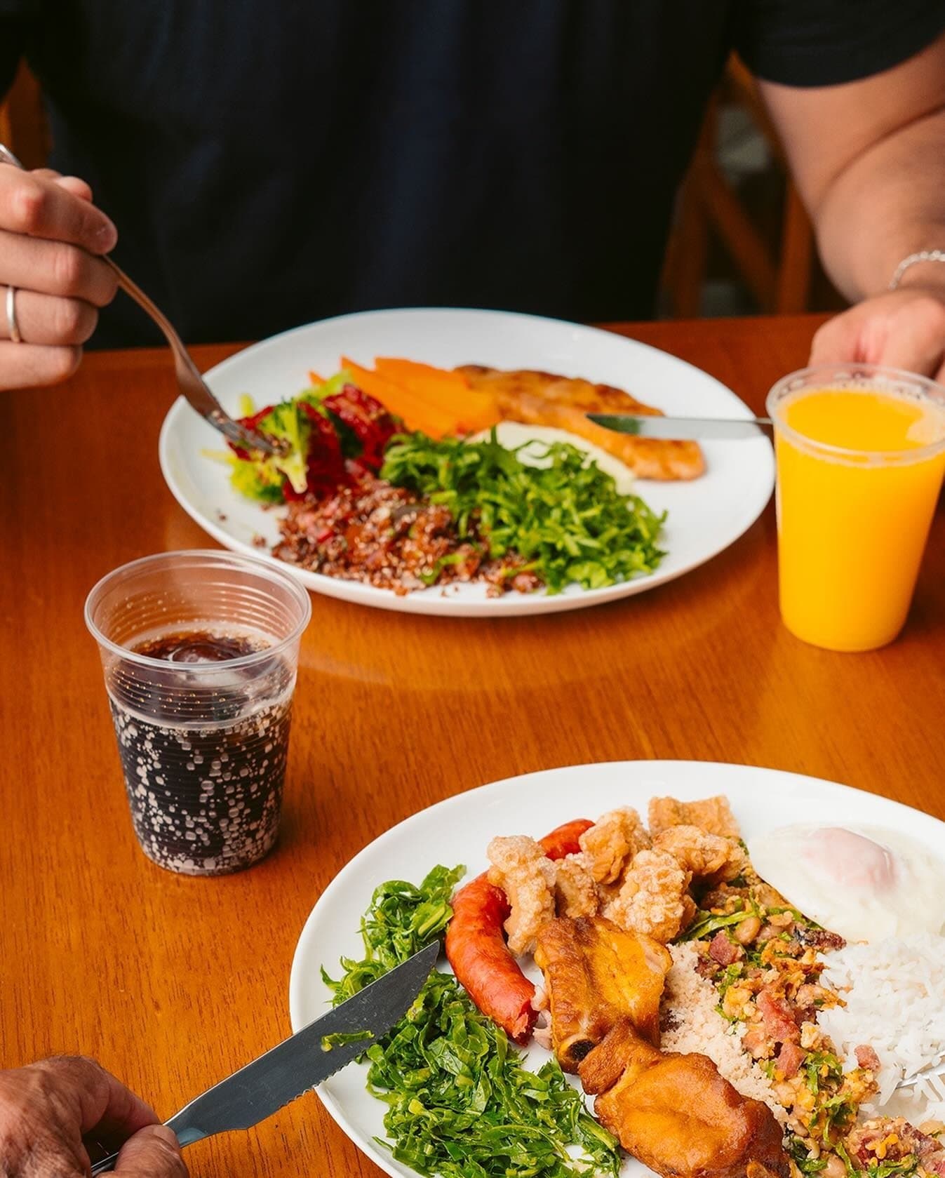 Duas pessoas almoçando no salão do Vila Rica